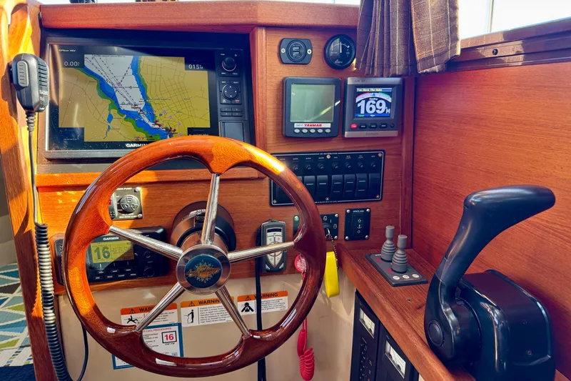 Slide: The Image of Steering console of 2012 Ranger 27 boat with navigation equipment and wooden wheel. - 32