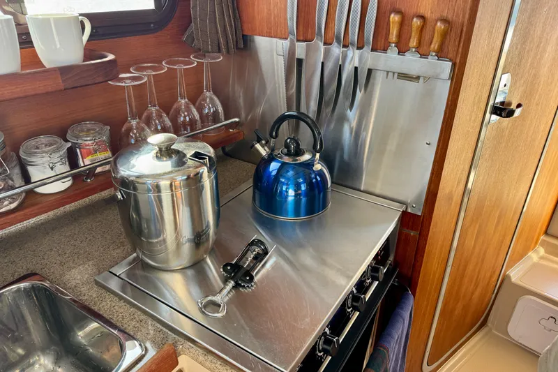 Slide: The Image of Compact kitchen in 2012 Ranger 27 boat with kettle, knives, and glassware. - 37