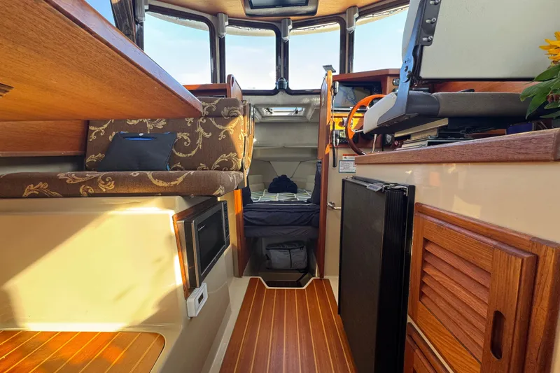 Slide: The Image of Interior of 2012 Ranger 27 boat with wood accents and cozy seating area. - 39
