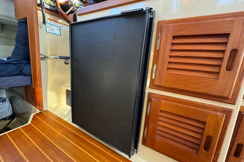 Slide: The Image of Interior of 2012 Ranger 27 boat with wooden cabinets and black panel. - 40