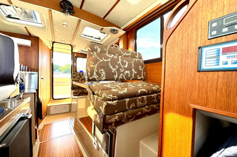 Slide: The Image of Interior of 2012 Ranger 27 boat with patterned seating and wooden finishes. - 43