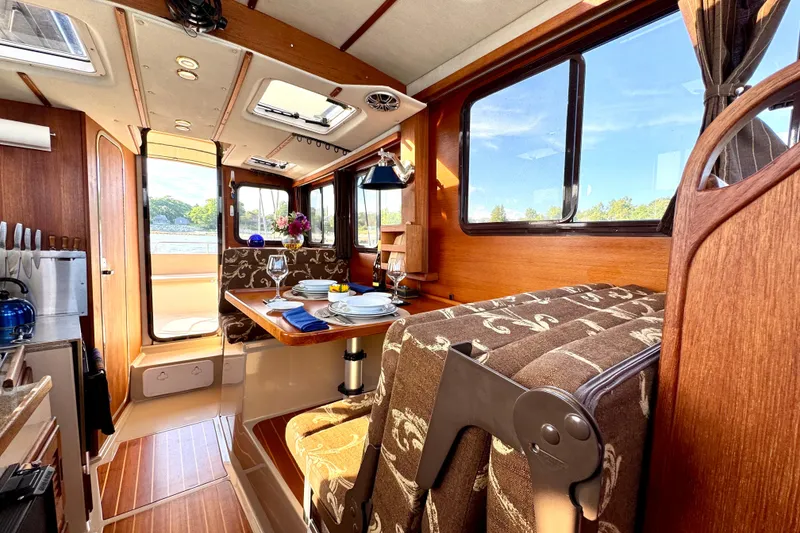 Slide: The Image of Cozy interior of 2012 Ranger 27 boat with dining area and scenic window views. - 44