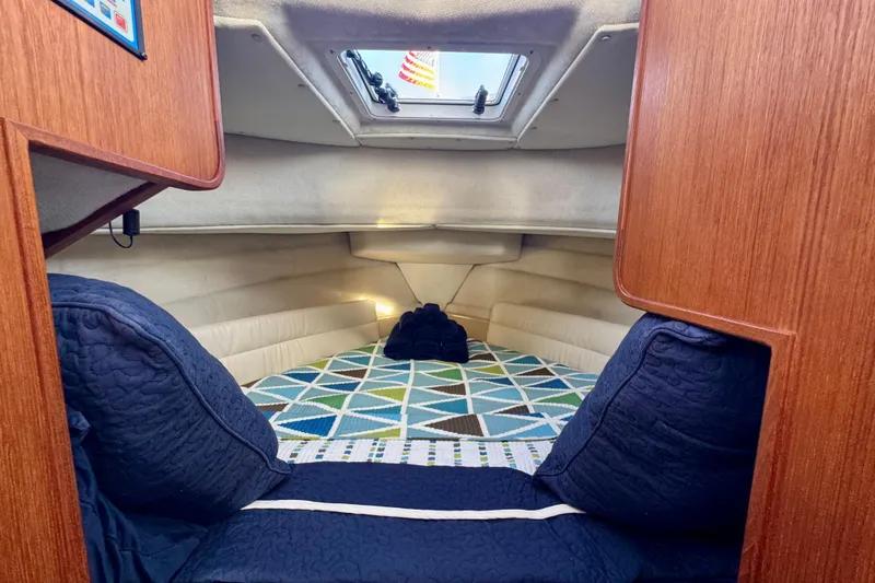 Slide: The Image of Cozy cabin interior of 2012 Ranger 27 boat with geometric bedding and wood paneling. - 45