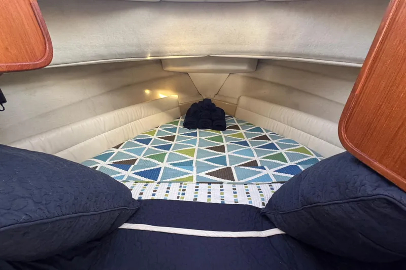 Slide: The Image of Cozy cabin interior of 2012 Ranger 27 boat with geometric-patterned bedding. - 46
