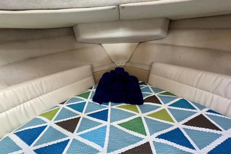 Slide: The Image of Cozy cabin interior of 2012 Ranger 27 boat with geometric-patterned bedding. - 47