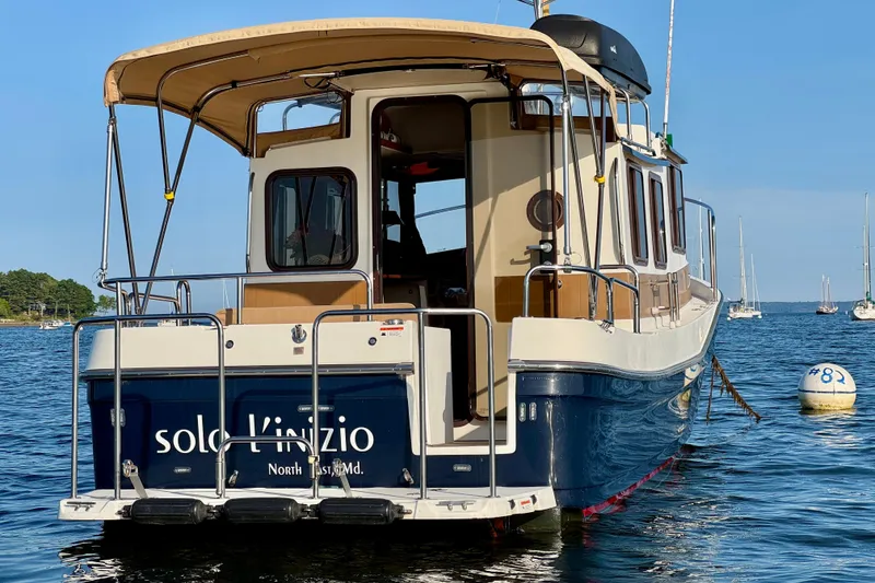 Slide: The Image of 2012 Ranger 27 boat docked on calm water, featuring a beige canopy and sleek design. - 5