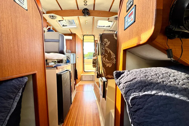 Slide: The Image of Interior of 2012 Ranger 27 boat, featuring wood paneling and modern amenities. - 50