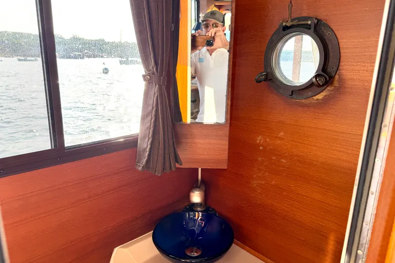 Slide: The Image of Interior of 2012 Ranger 27 boat with sink, mirror, and porthole window. - 57