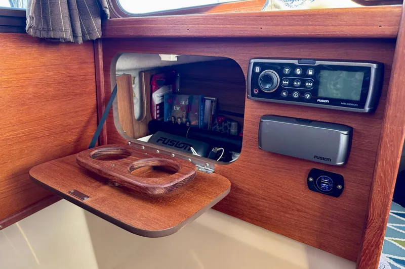 Slide: The Image of Interior of 2012 Ranger 27 boat with wooden panel, stereo system, and cup holders. - 58