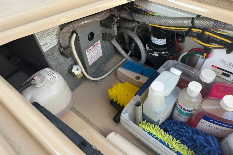 Slide: The Image of Storage compartment of a 2012 Ranger 27 boat with cleaning supplies and equipment. - 70