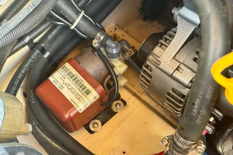 Slide: The Image of Engine components of a 2012 Ranger 27, featuring alternator and wiring. - 84