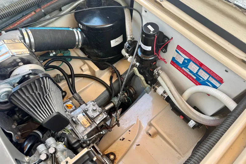 Slide: The Image of Engine compartment of a 2012 Ranger 27 boat, showcasing mechanical components and hoses. - 86