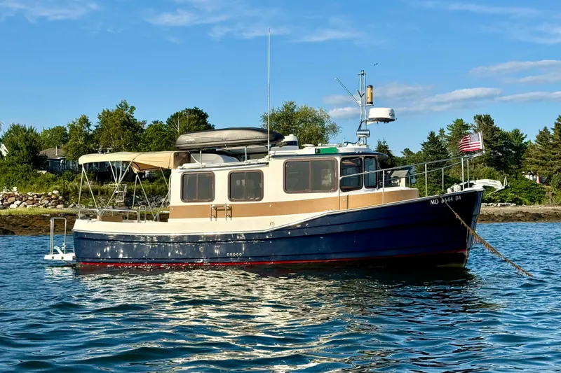 Slide: The Image of 2012 Ranger 27 boat anchored on calm water with scenic shoreline background. - 94
