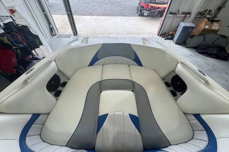 Slide: The Image of 2019 MB F22 Tomcat boat interior with white, gray, and blue seating in a garage. - 13