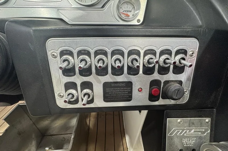 Slide: The Image of Control panel of 2019 MB F22 Tomcat boat with various switches and warning label. - 26