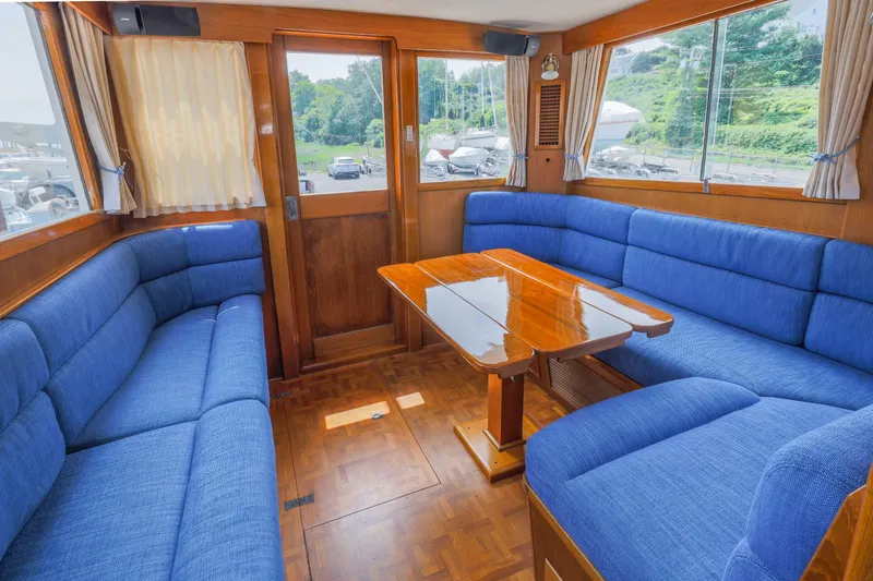 Slide: The Image of Interior of 1988 Grand Banks 36 Sedan with blue seating and wooden table. - 10