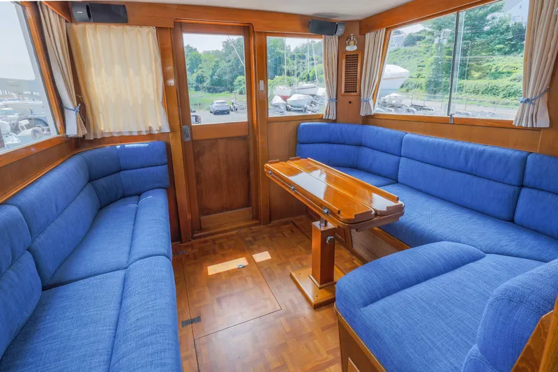 Slide: The Image of Interior of 1988 Grand Banks 36 Sedan with blue seating and wooden table. - 11