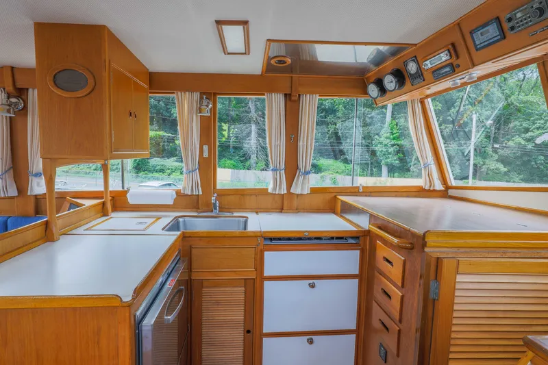 Slide: The Image of 1988 Grand Banks 36 Sedan interior with wooden cabinetry and large windows. - 13