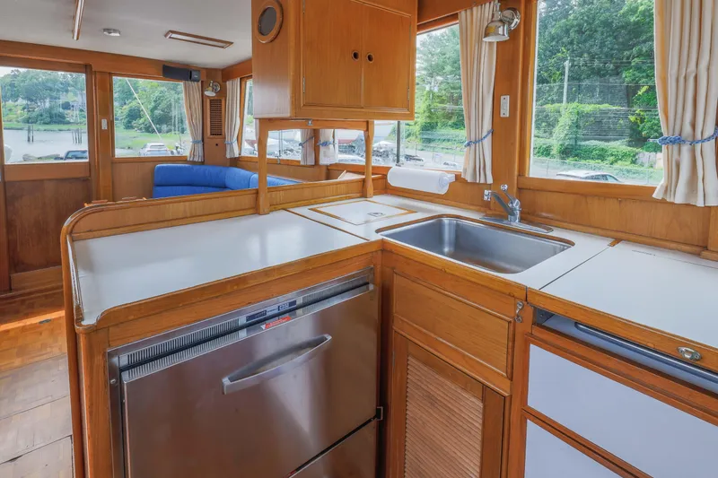 Slide: The Image of Interior of 1988 Grand Banks 36 Sedan, featuring a wooden kitchen with sink and appliances. - 15