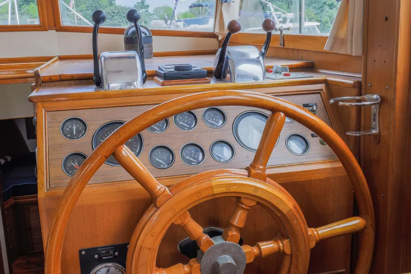 Slide: The Image of 1988 Grand Banks 36 Sedan helm with wooden wheel and control panel. - 16