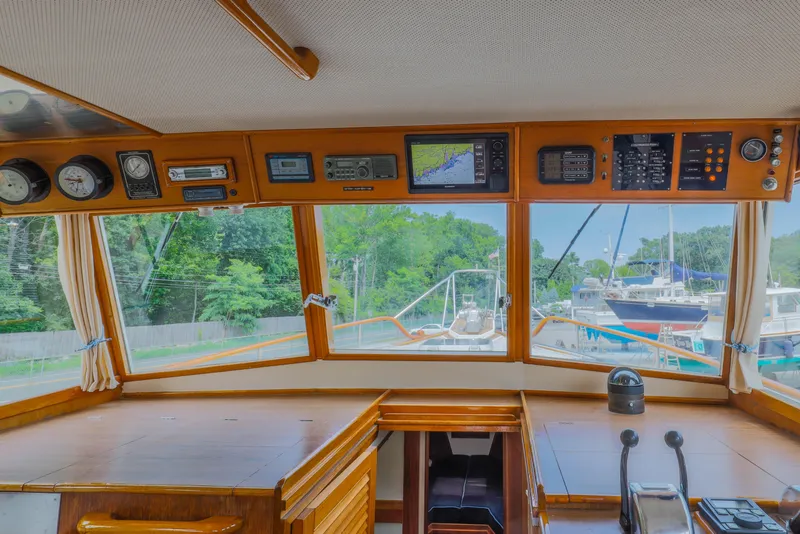 Slide: The Image of 1988 Grand Banks 36 Sedan helm with navigation instruments and marina view. - 17