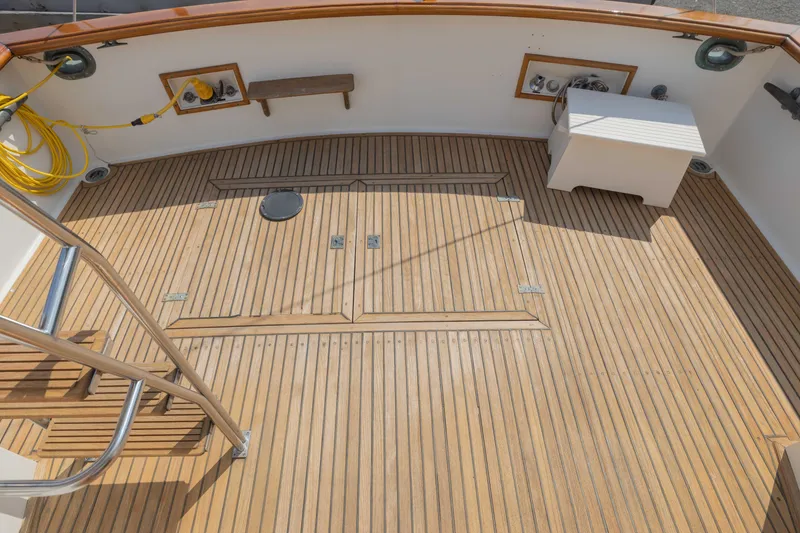 Slide: The Image of 1988 Grand Banks 36 Sedan boat deck with teak flooring and stainless steel ladder. - 21