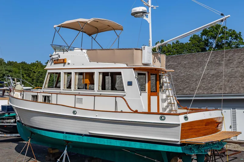 Slide: The Image of 1988 Grand Banks 36 Sedan boat on dry dock, showcasing classic design and wooden accents. - 29