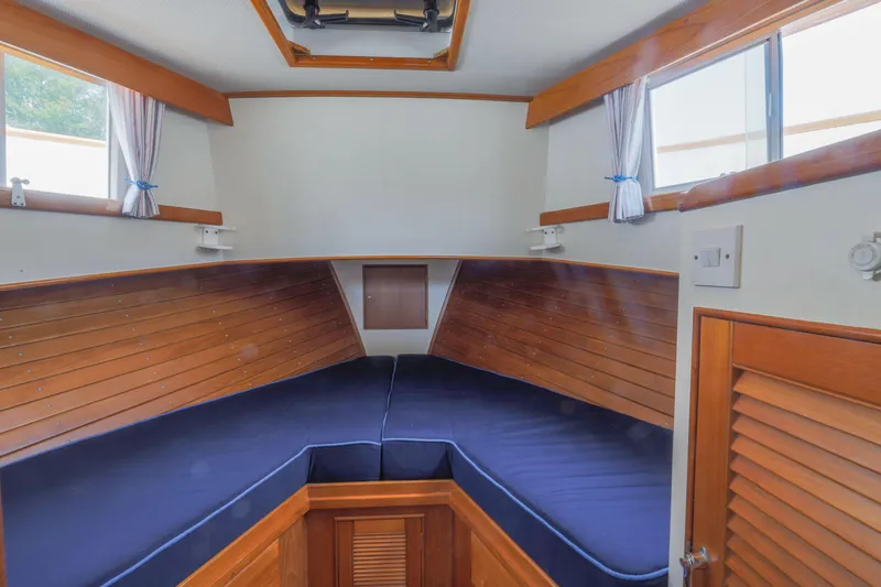 Slide: The Image of Interior cabin of 1988 Grand Banks 36 Sedan with wooden paneling and blue cushions. - 4