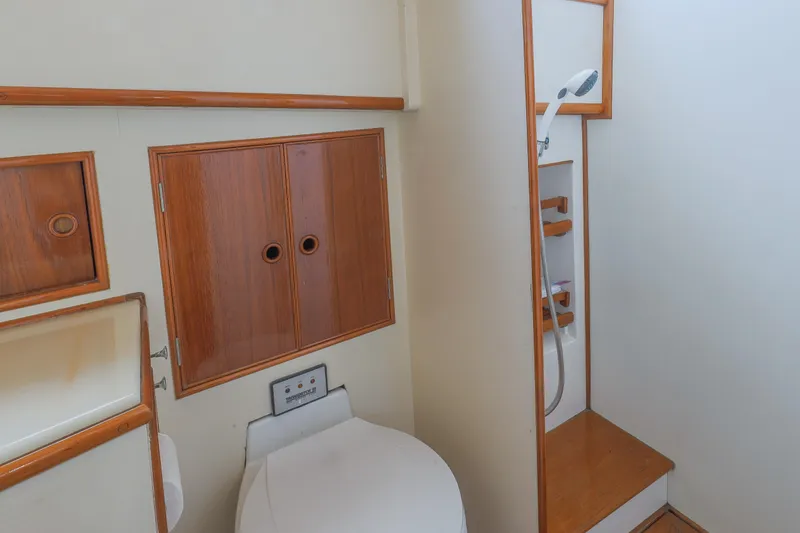Slide: The Image of 1988 Grand Banks 36 Sedan bathroom with wooden cabinets and shower area. - 8
