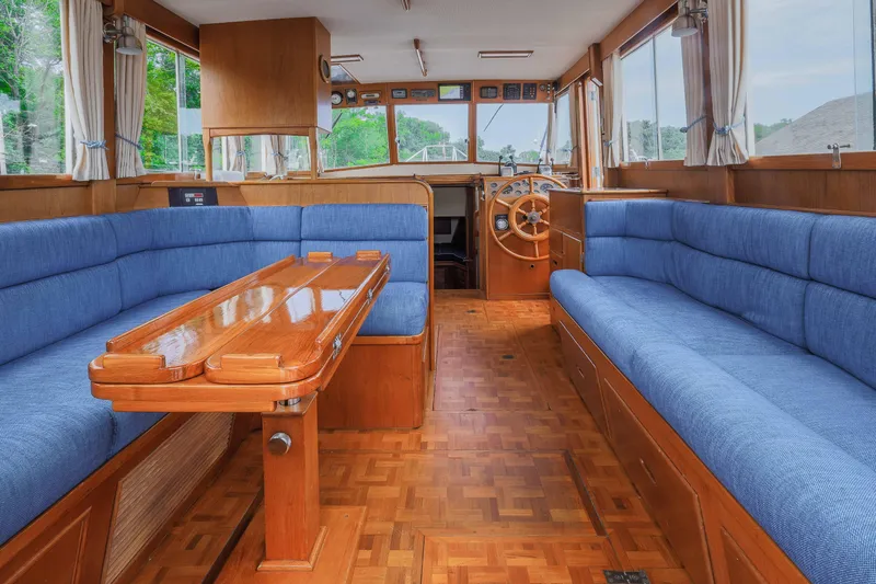 Slide: The Image of Interior of 1988 Grand Banks 36 Sedan with blue seating and wooden accents. - 9