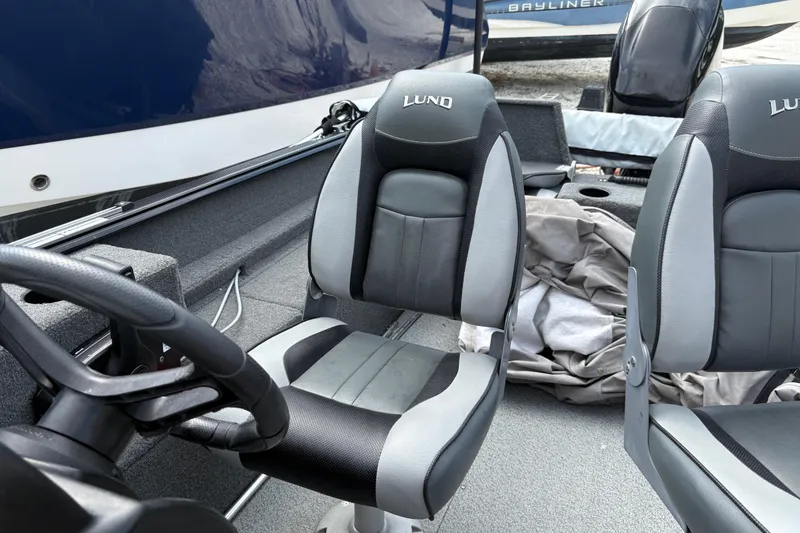 Slide: The Image of 2015 Lund 1650 Rebel XL Sport boat interior with steering wheel and seats. - 11