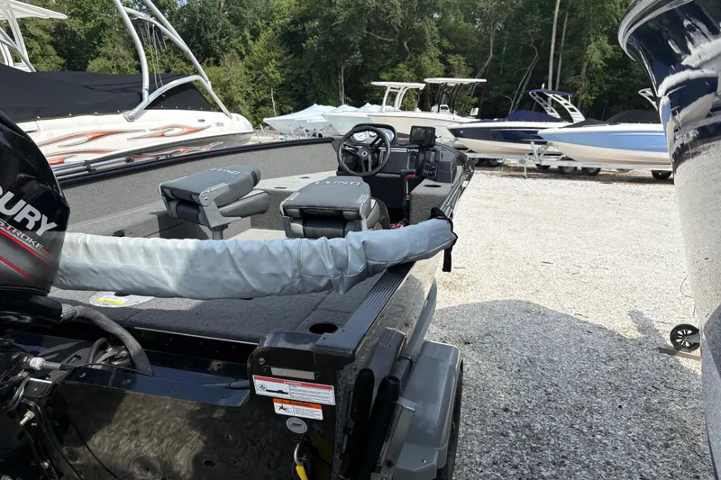 Slide: The Image of 2015 Lund 1650 Rebel XL Sport boat with Mercury engine in a marina setting. - 5