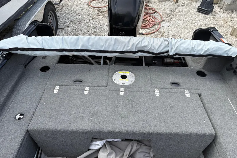 Slide: The Image of 2015 Lund 1650 Rebel XL Sport boat interior with storage compartments and motor. - 6