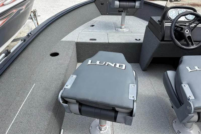 Slide: The Image of 2015 Lund 1650 Rebel XL Sport boat interior with seating and steering wheel. - 9