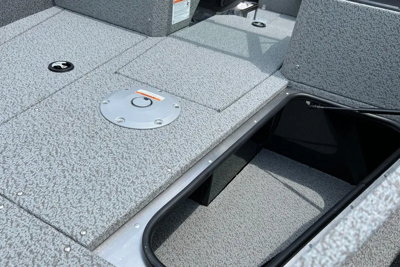 Slide: The Image of 2025 Lund 1775 Adventure Sport boat interior with storage compartment and textured flooring. - 10