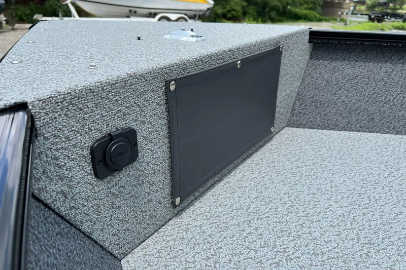 Slide: The Image of 2025 Lund 1775 Adventure Sport boat interior with textured gray upholstery and storage compartment. - 11