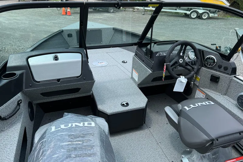 Slide: The Image of 2025 Lund 1775 Adventure Sport boat interior with steering wheel and seating. - 14