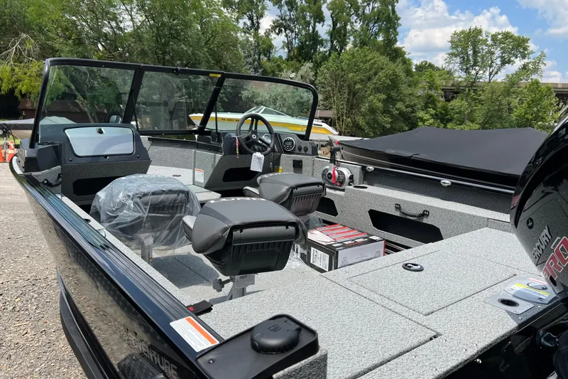 Slide: The Image of 2025 Lund 1775 Adventure Sport boat interior with seating and controls, set outdoors. - 7