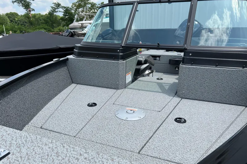Slide: The Image of 2025 Lund 1775 Adventure Sport boat interior with gray textured flooring and windshield. - 9