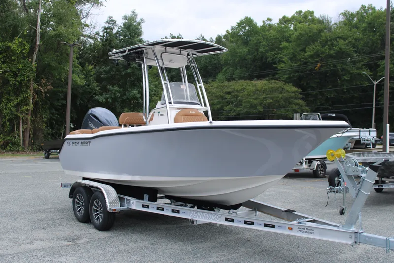 The Image of 2026 Key West 203 FS boat on trailer in parking lot, surrounded by trees. - 0