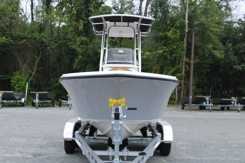 Slide: The Image of 2026 Key West 203 FS boat on trailer, parked outdoors near blue building. - 1