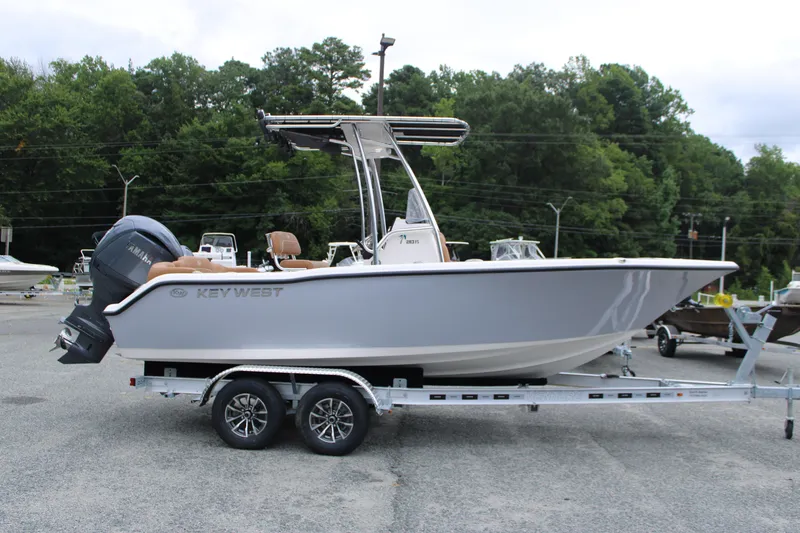 Slide: The Image of 2026 Key West 203 FS boat on trailer, parked outside blue building. - 3