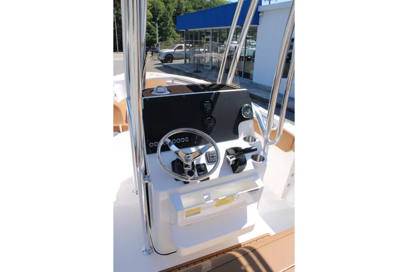 Slide: The Image of 2026 Key West 203 FS boat console with steering wheel and controls, parked near a dealership. - 9