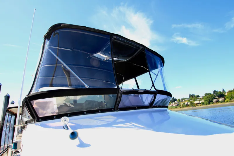Slide: The Image of 1987 Ocean Alexander 42 yacht with clear canopy, docked under blue sky. - 11