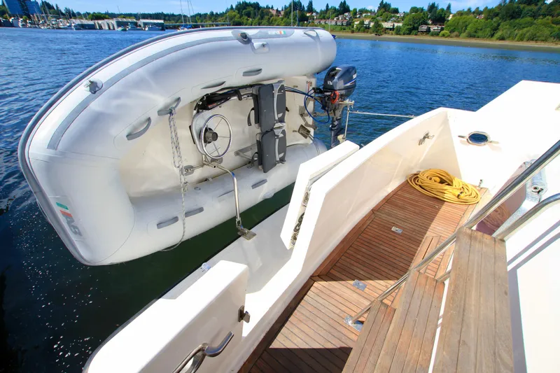 Slide: The Image of 1987 Ocean Alexander 42 yacht with inflatable dinghy on deck, docked by scenic shoreline. - 15