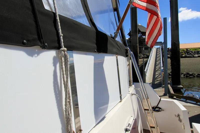 Slide: The Image of 1987 Ocean Alexander 42 yacht docked, featuring American flag and marina view. - 18