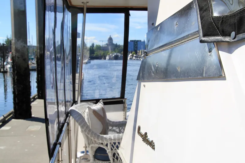 Slide: The Image of 1987 Ocean Alexander 42 yacht docked, featuring wicker seating and scenic waterfront view. - 19