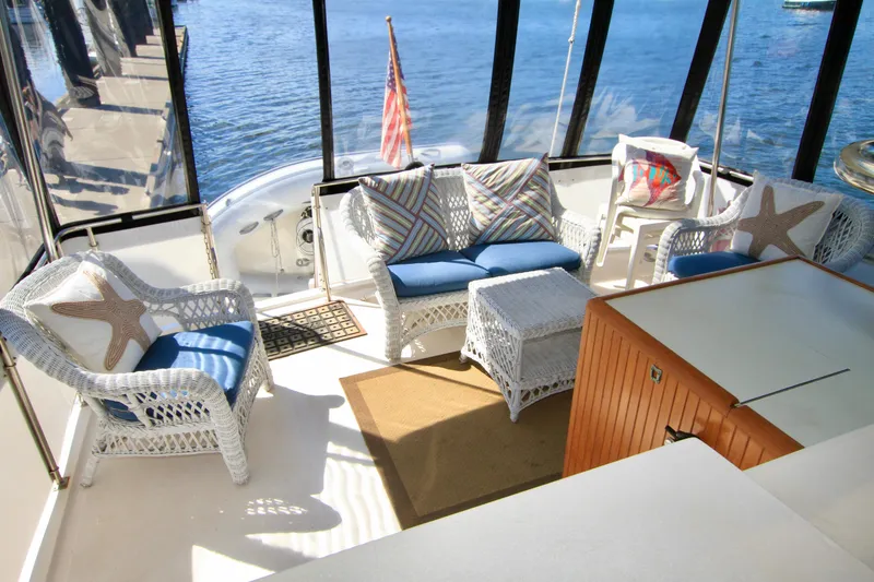 Slide: The Image of 1987 Ocean Alexander 42 yacht interior with wicker furniture and scenic water view. - 23