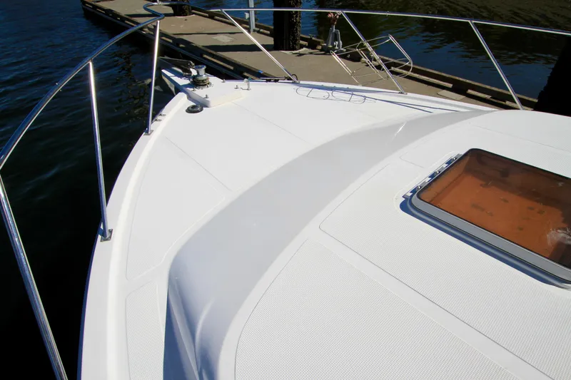 Slide: The Image of 1987 Ocean Alexander 42 yacht deck with railing and hatch, docked by the water. - 4