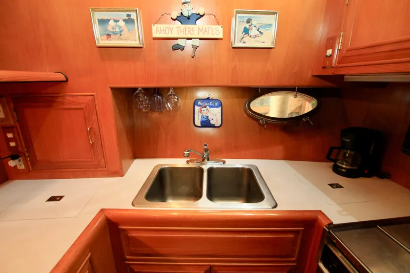 Slide: The Image of 1987 Ocean Alexander 42 yacht kitchen with double sink, wooden cabinets, and nautical decor. - 44